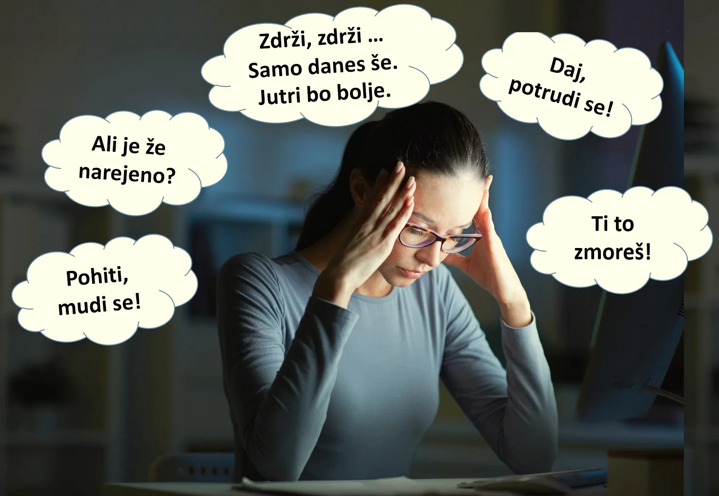 Kobieta w okularach siedzi wieczorem przy komputerze i trzyma się za głowę, otoczona dymkami myśli po słoweńsku ponaglających ją do pracy